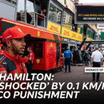 Lewis Hamilton in Ferrari team gear in the Monaco Grand Prix pit lane next to an FIA graphic detailing his 0.1 km/h speed limit penalty violation.