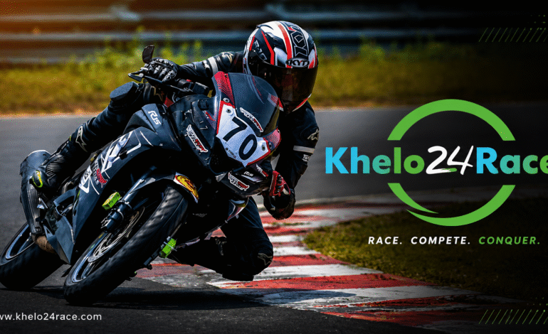 What is a Racer Bike leaning aggressively through a racetrack corner with the Khelo24Race logo, showcasing high-speed motorcycle racing and professional track performance.