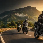 Three adventure bikes riders touring on a winding mountain road in India at sunrise.